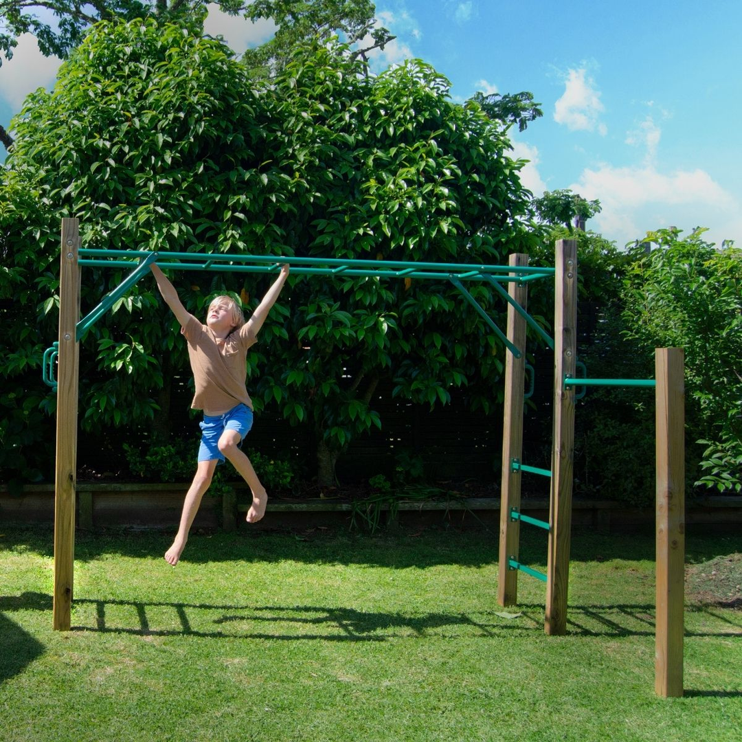 Boy swinging across monkey bars outside.
