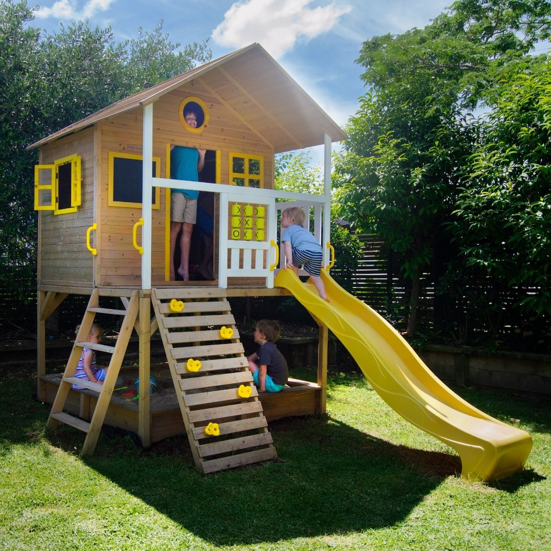 Kids having fun in two story outdoor play centre in the backyard.